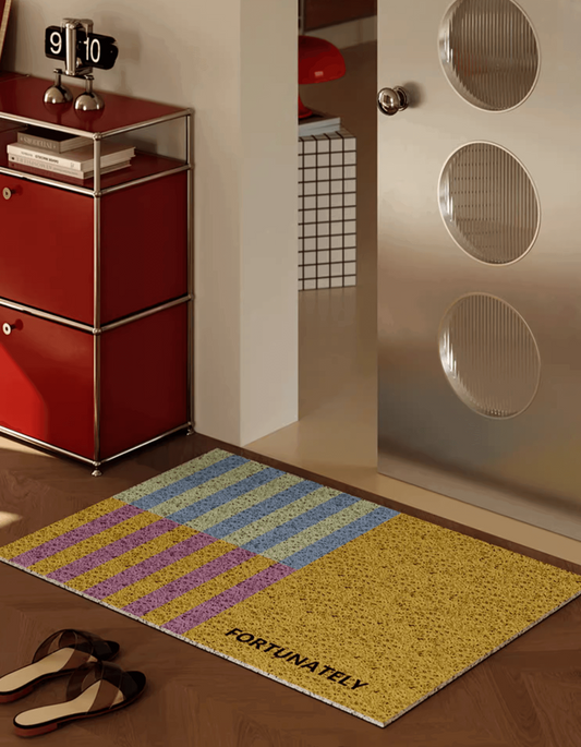 Zuumat unique doormat for home featuring colorful striped design and FortunaTely text by a modern door
